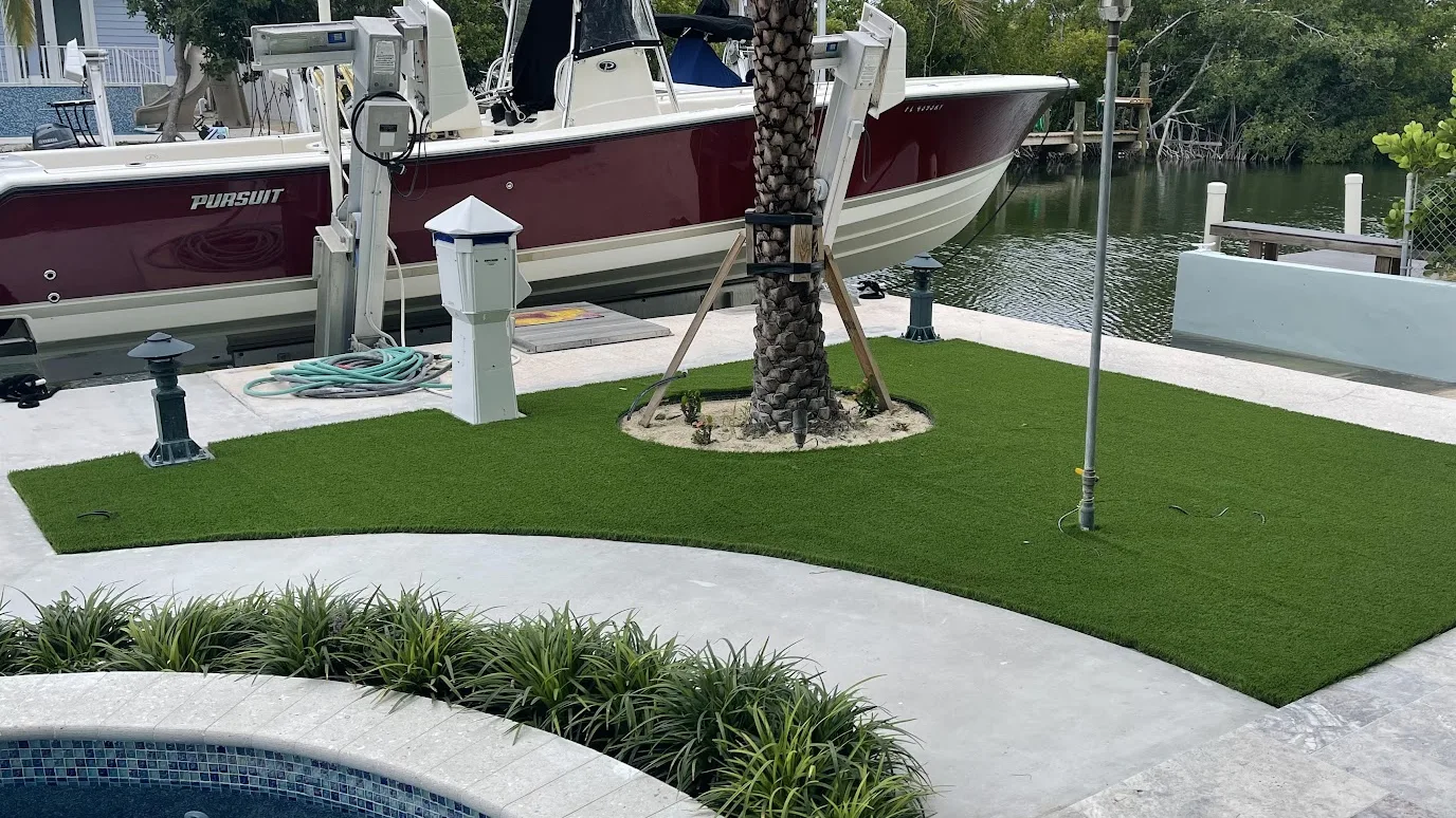 A finished AJ Turf lawn curving between a boat dock and a pool