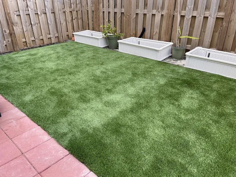 Small fenced turf yard with white planter boxes