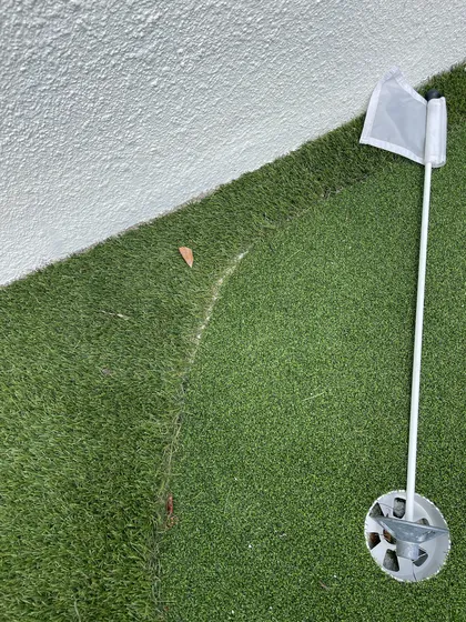Finished putting-green edge glued clean to a white border, no spikes